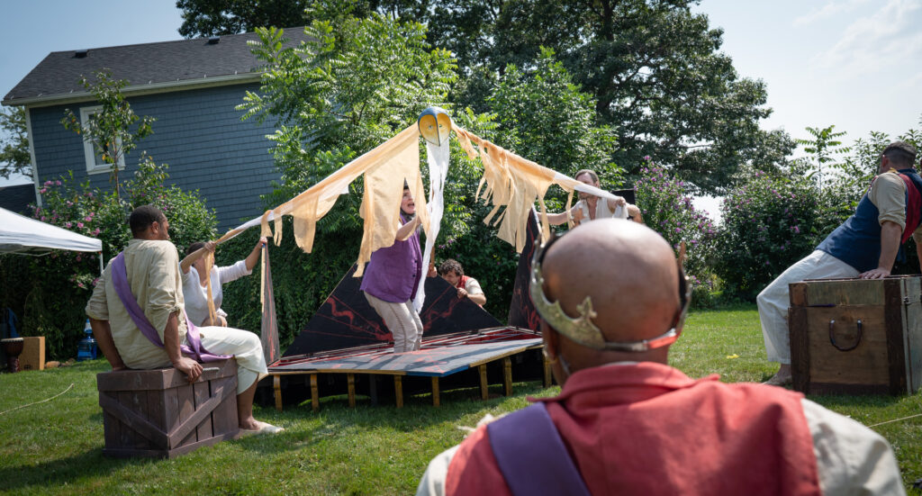 Puppet representing the Harpy scene in the Tempest terrifies a king in the foreground played by an actor