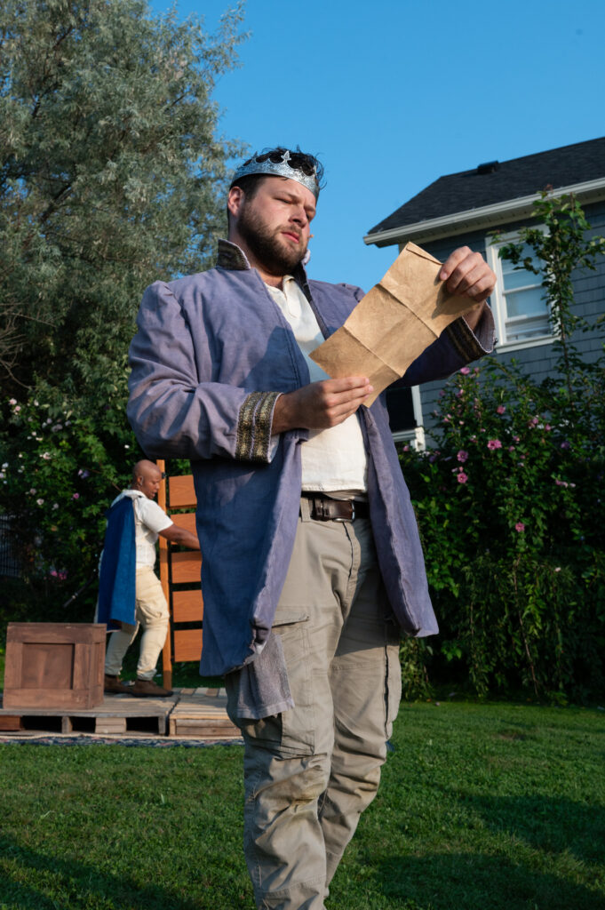 Man with a crown reading a letter